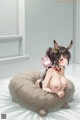 A woman sitting on top of a bean bag chair with a piggy bank.