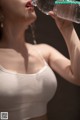 A woman drinking water from a bottle. 