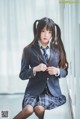 A woman in a school uniform sitting on a window sill.