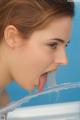 A young woman sticking out her tongue in a bathtub.