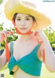 A woman in a straw hat is posing for a picture.