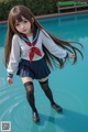 A girl in a school uniform standing in a pool.